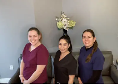 the Clayton Dental Group staff smiling together in the waiting room