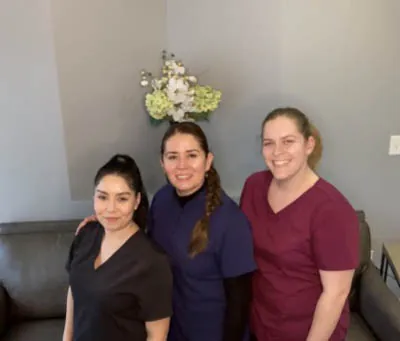 the Clayton Dental Group staff smiling together in the waiting room