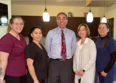 Mehran Haidari, DMD smiling together with his staff