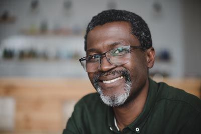 man smiling after all-on-4 dental implants from Clayton Dental Group helped restore his smile