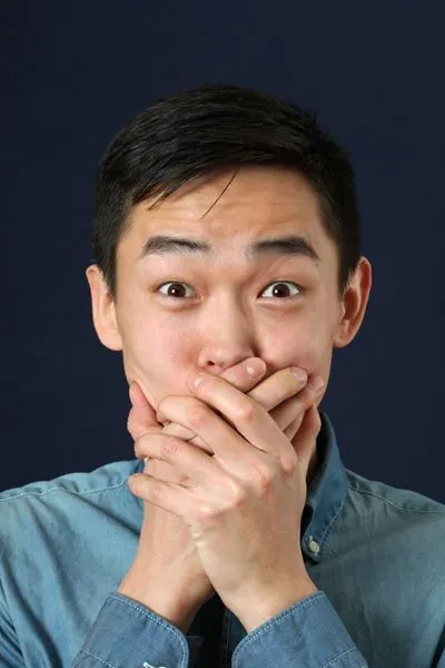 man holding his mouth due to tooth pain