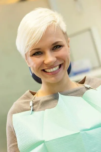 patient showing off her smile after osseous surgery