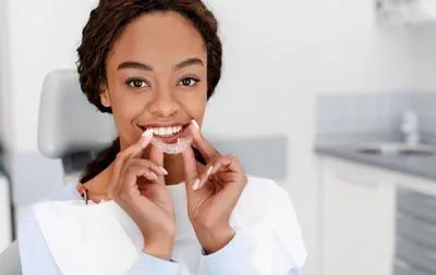 patient holding her new Invisalign aligners
