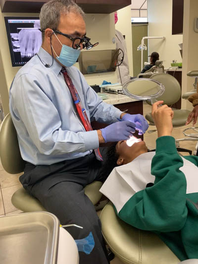 Dr. Haidari working on a patient's teeth