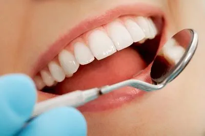 dentist checking on a patient's teeth after gum disease treatment